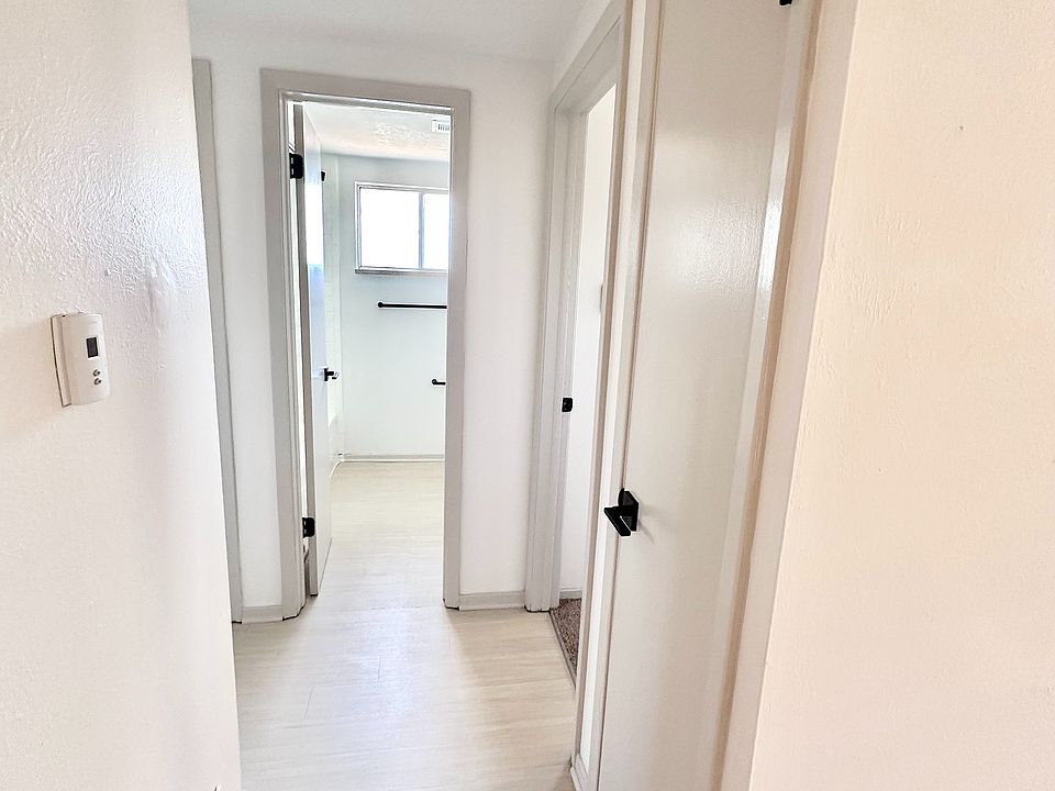 Bright and inviting hallway with modern doors in a contemporary apartment, featuring sleek finishes and light wood flooring.