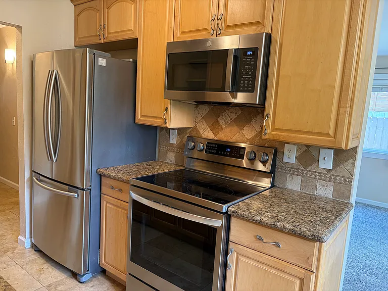 Beautifully upgraded galley kitchen - granite tops, all stainless steel appliances. Custom wine rack and end cap racks. Illuminated cabinet and black designer stone sink. Dishwasher. Brand new gas stove, microwave and refrigerator. Custom chandeleiir.