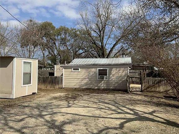 Parking area with view of house and storage shed.