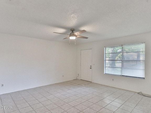 Front door enters to living area with front window to yard and driveway.