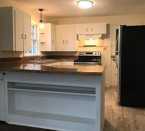 Breakfast bar is ready for stools with shelves underneath for storage.