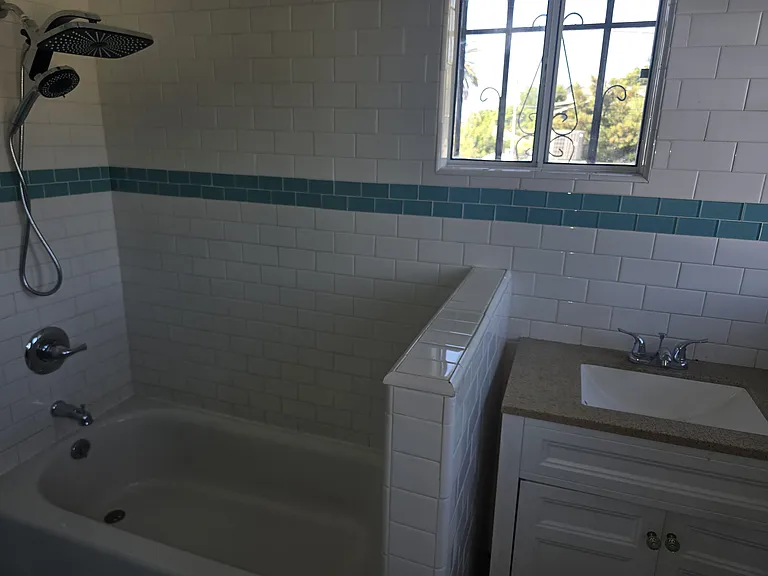 Bathroom area with tub showerhead and sink