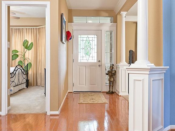 Entry has a leaded glass door, hardwood floors and recessed lighting.