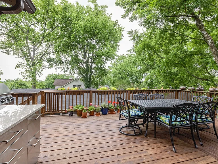 Spacious deck with outdoor dining area and mature tree views.