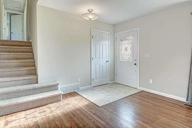 Entry with convenient coat closet, onto wood floor living ro