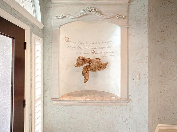Professional faux finishes in grand entry are hilited with this custom installation.  It may staywith buyers as a beautiful welcome to your guests at 51 N Crescndo Path Place.