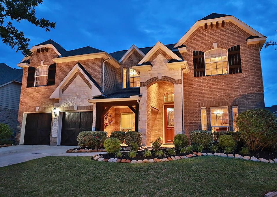 FIVE BEDROOM HOME ON QUIET STREET - Refinement meets tradition in this stately beauty. Exterior features a brick and stone facade with recently stained rustic cedar wood trim and "barn-like" garage doors. Pristine front landscaping with designer rock
