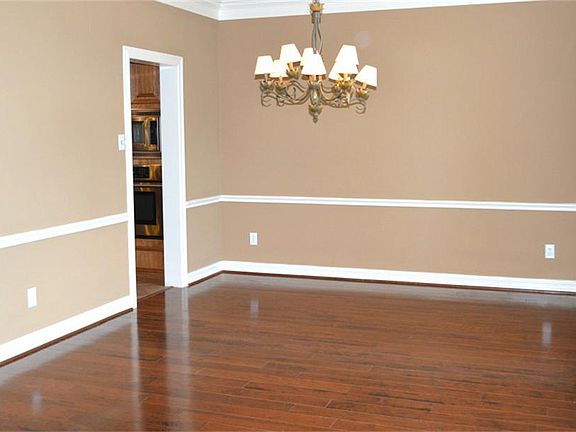 Nice dining room with a neutral palette and lovely light fixture.