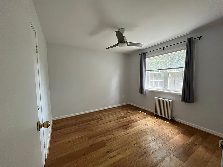 Bedroom, windows face back courtyard. Radiator heat and fan
