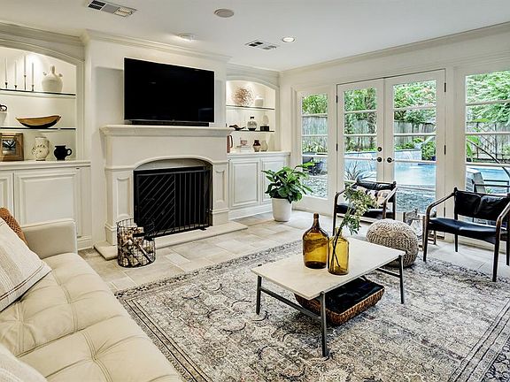 Enjoy the wood burning fireplace flanked with built-in display shelving and enclosed storage below
