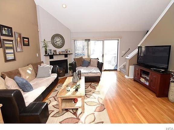 Triple sliding glass door from deck to sun filled living room with fireplace and cathedral ceilings.