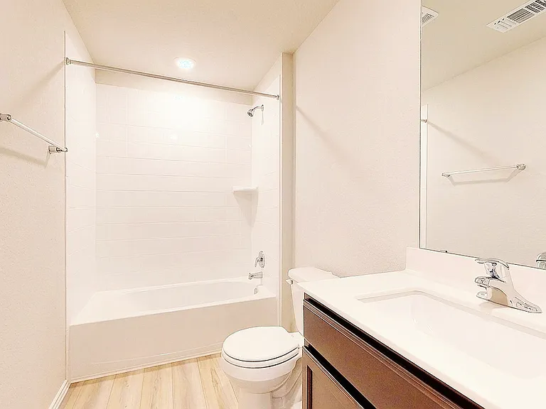 Second full bathroom with a tub/shower combo, single-sink vanity, and large mirror.