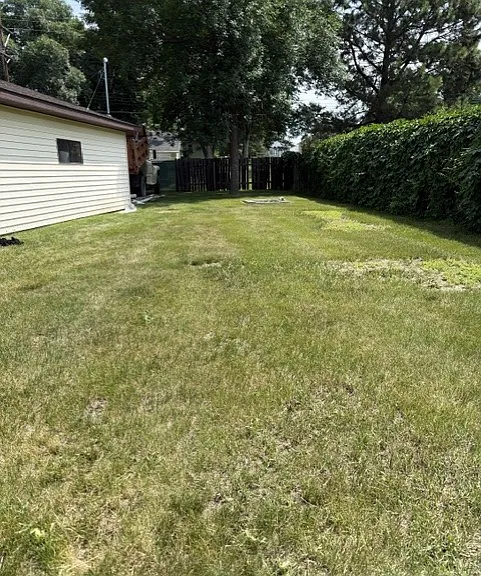 Large yard with garden shed and garage.
