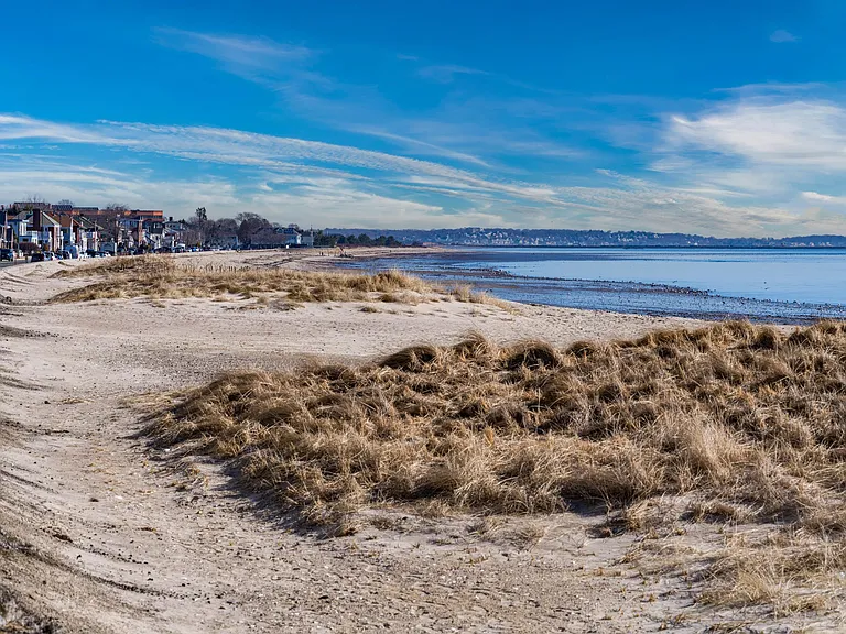 A relaxed shoreline setting with sandy paths and water views stretching along the coast.
