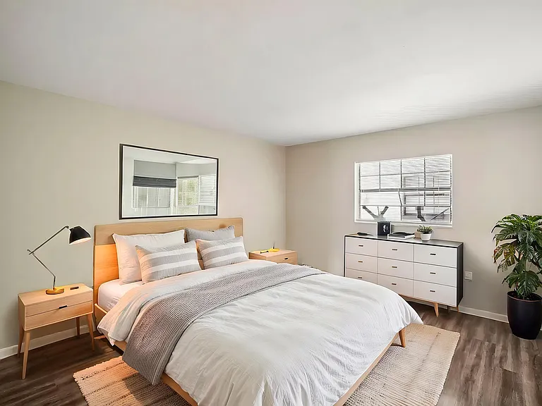 Inviting bedroom with modern decor, featuring a cozy bed, natural light, and stylish furnishings.