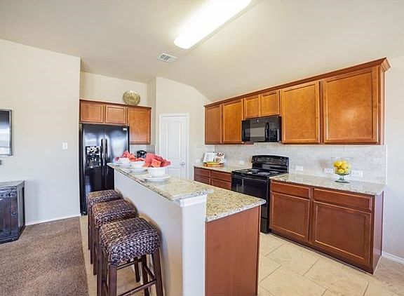 Kitchen with bar, granite counters and 18" ceramic tile.
