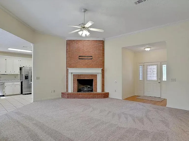 View of front door, fireplace, kitchen view to the left