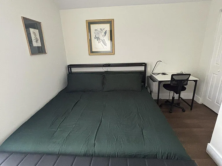Furnished bedroom with a King bed, accent artwork, and a dedicated desk setupideal for studying or working from home.