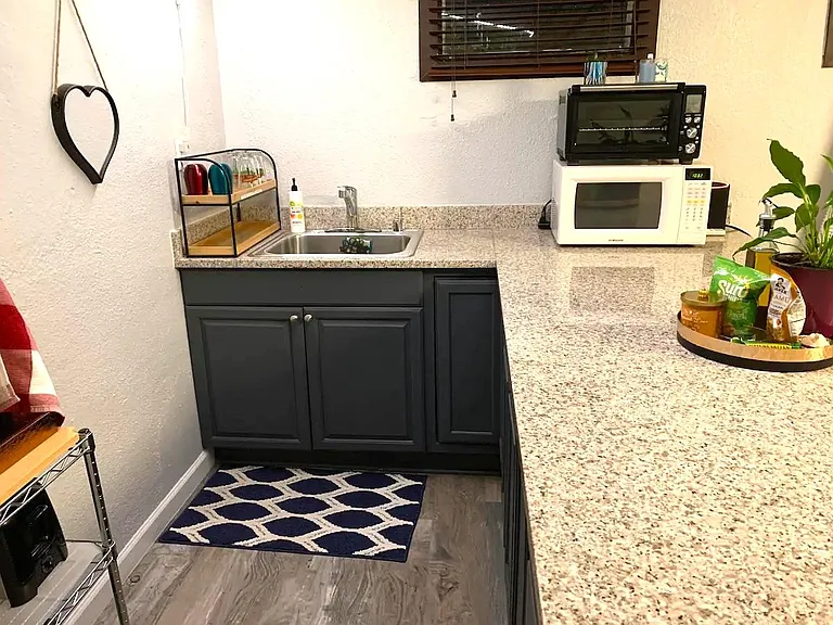 Kitchen equipped with hot place, InstaPot, microwave, toaster, apartment size refrigerator.