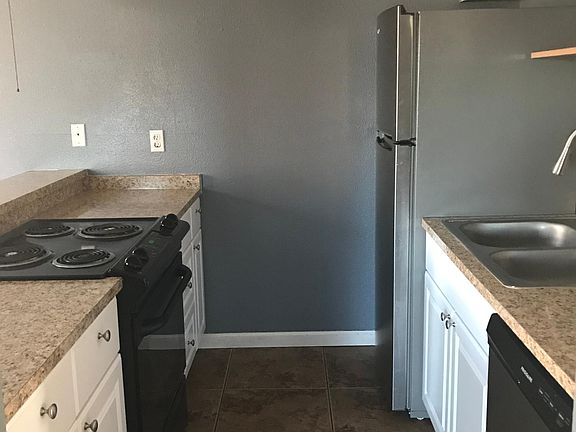 The kitchen includes a refrigerator, dishwasher, and oven.
