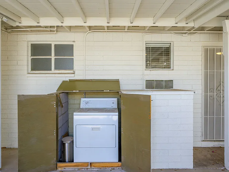 Private dryer attached to exterior of building in carport