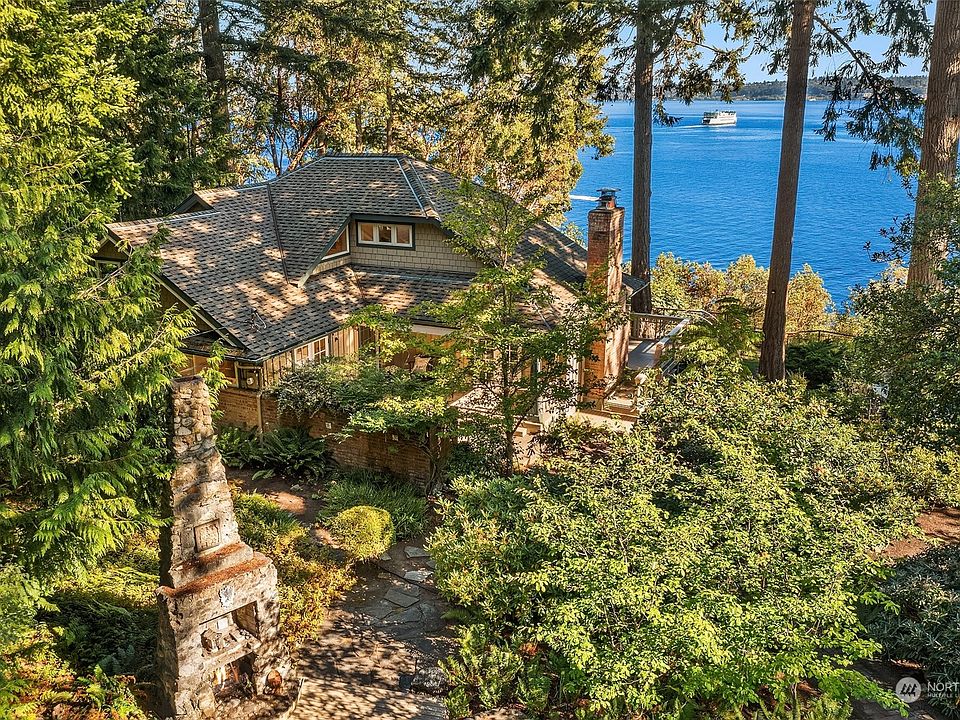 The home is nestled amongst tall trees with gorgeous southern views of Puget Sound, Mt. Rainier and Tacoma.>