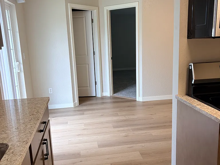 View from kitchen to primary bedroom and main bathroom