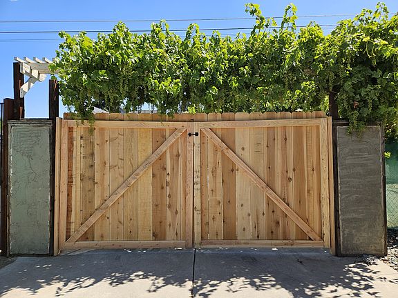 Entrance into fenced property. Champagne grapevine over 2 door/gate entrance