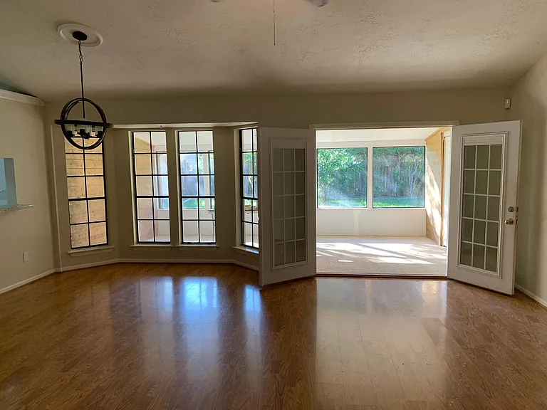 Large combined family room with dining area. Opens to sun/bonus room. View of backyard.