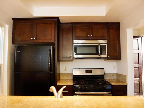 Kitchen with refrigerator, gas stove, dishwasher and microwave.