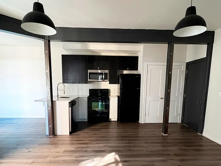 High ceilings and bold dark accents highlight this authentic loft interior, waiting for your personal touch.