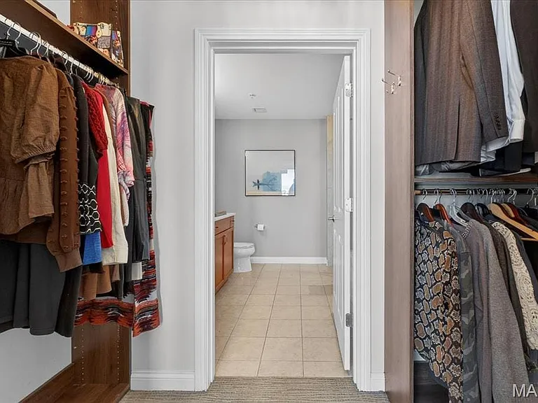 Walk-in closet leading to primary bathroom