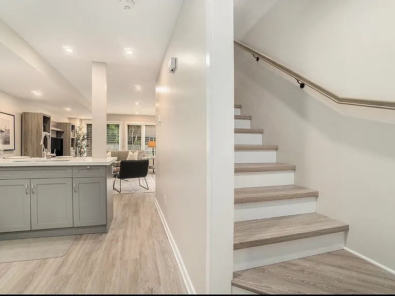 Modern staircase leading to a bedroom, den, full bathroom and laundry area in this bright, furnished West Ottawa midterm rental.