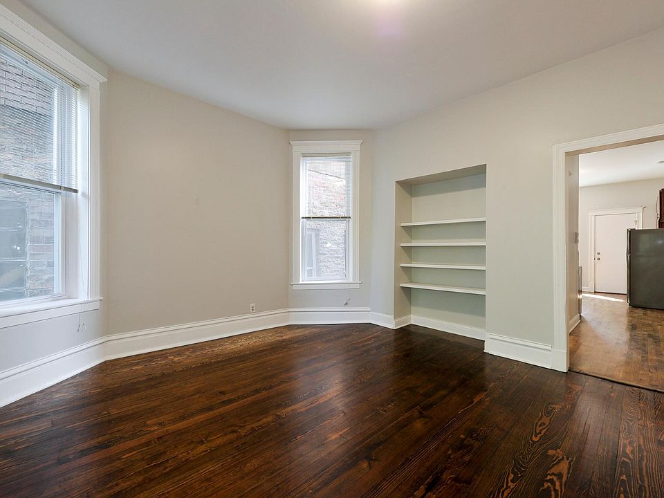LIVING ROOM WITH BUILT INS AND LARGE 82 IN WINDOWS