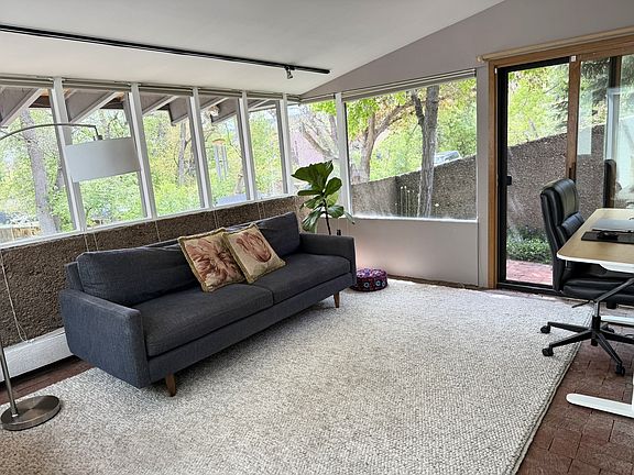 Front Office with sofa for reading, desk and small bricked patio.