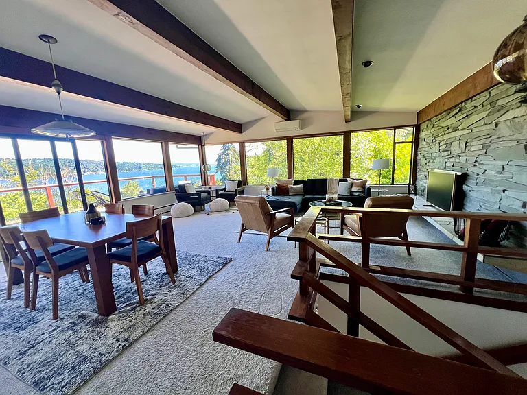 Another view of the open-concept main floor living room accented by a stone faced fireplace.