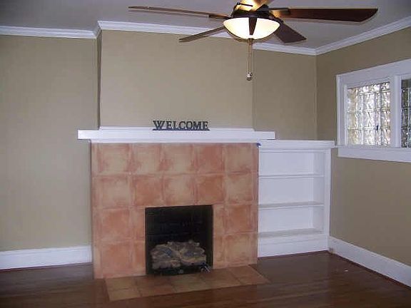 Living Room Features: Fireplace, Ceiling Fan & Built-in Bookshelf