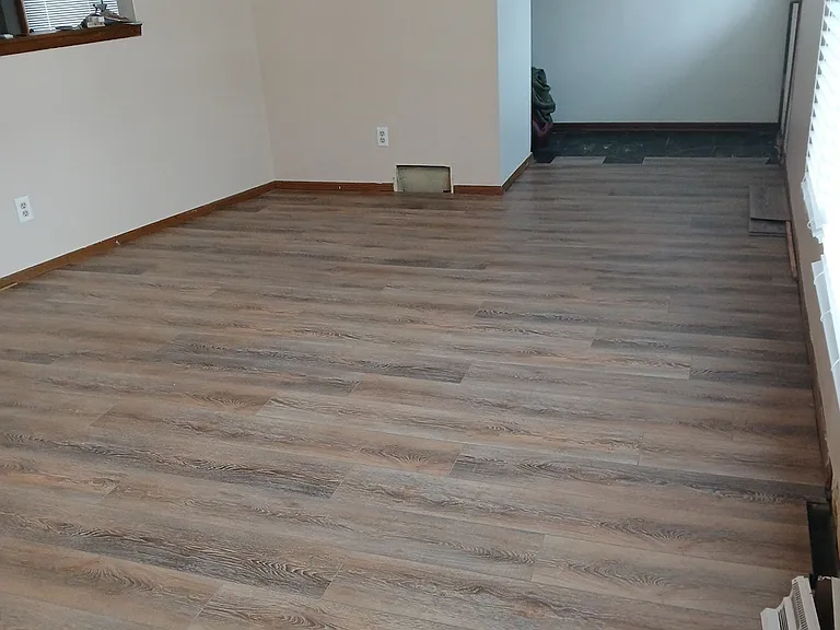 Another view of living room with entry door at the end of flooring on the right.