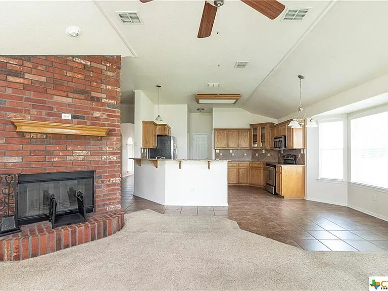 Family room off kitchen and dinette with pass through brick fireplace to living room.