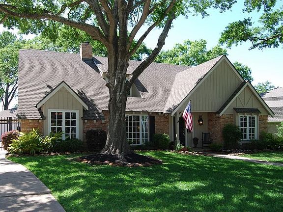 Gorgeous curb appeal, large trees and electric wrought-iron driveway gate.