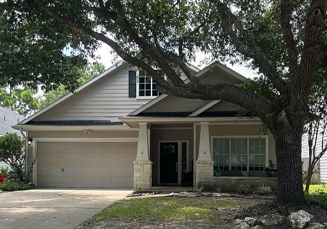 Beautiful home with a porch and large trees in the front yard.