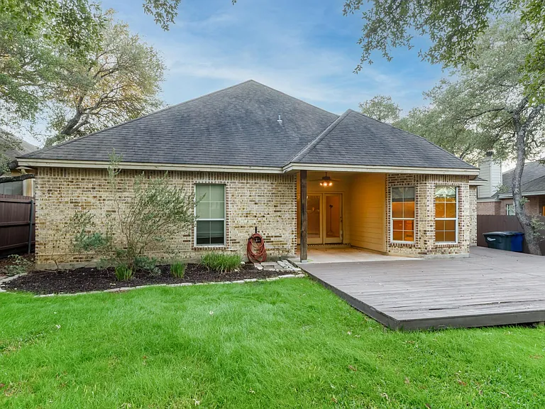 Fenced backyard has large deck and patio.