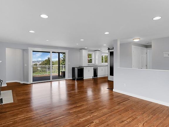 Living area looking back at the kitchen, pantry, and back deck