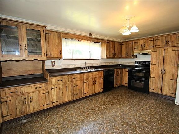 15x11 Eat in Kitchen has A Wall of Cabinetry, Vinyl Flooring, and a Large Wooden Pantry with Bonus Shelving (Located Next to Ref