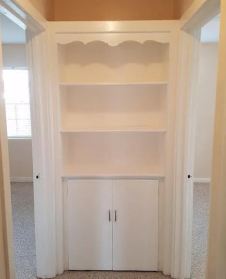 Hallway between 2 bedrooms with storage nook.