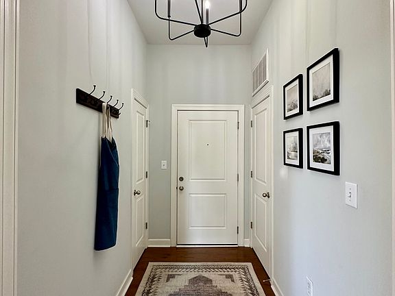 A welcoming entryway featuring high ceilings and a modern chandelier, creating a bright and airy feel.