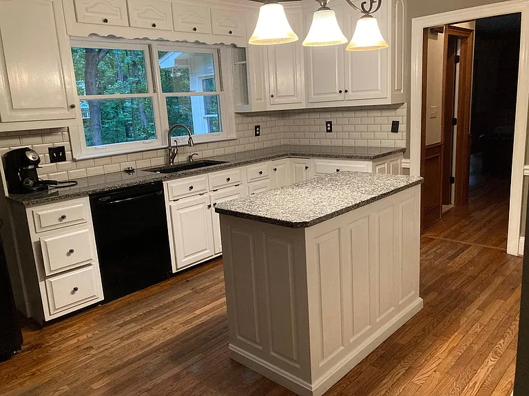 Another view of kitchen. Breakfast nook is to the left, half bath and family room to the right. There are two wall ovens and an electric cooktop across from island.
