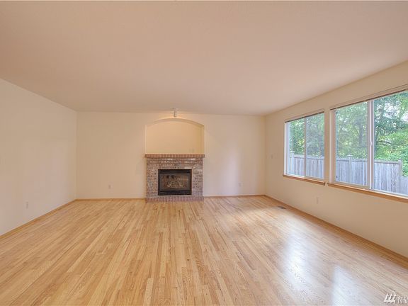 Gas fireplace and large windows looking out to greenbelt backyard give the living room a cozy feel. 