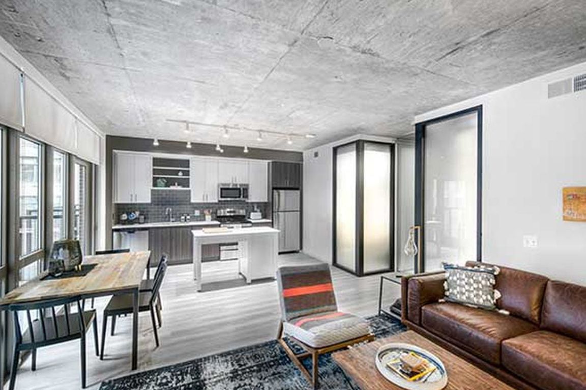 Open concept kitchen and living areas with hard surface flooring and floor to ceiling windows