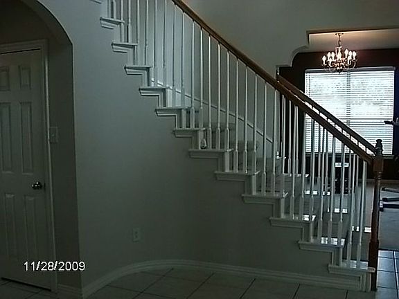 Curved staircase looking into formal dining room